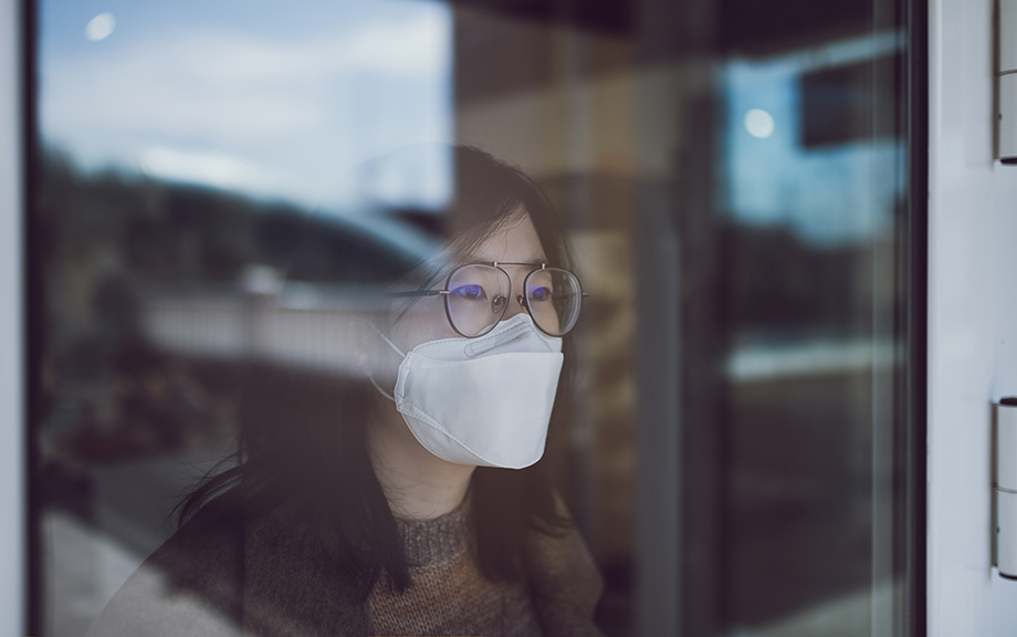 Asian Woman looking through window with mask
