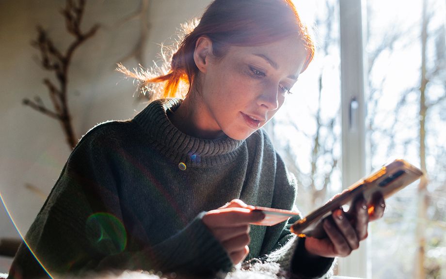 young Woman shopping online with laptop and credit card on hand.