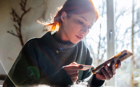 young Woman shopping online with laptop and credit card on hand.