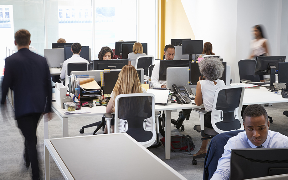 Decorative image: Man walking through a busy open plan office