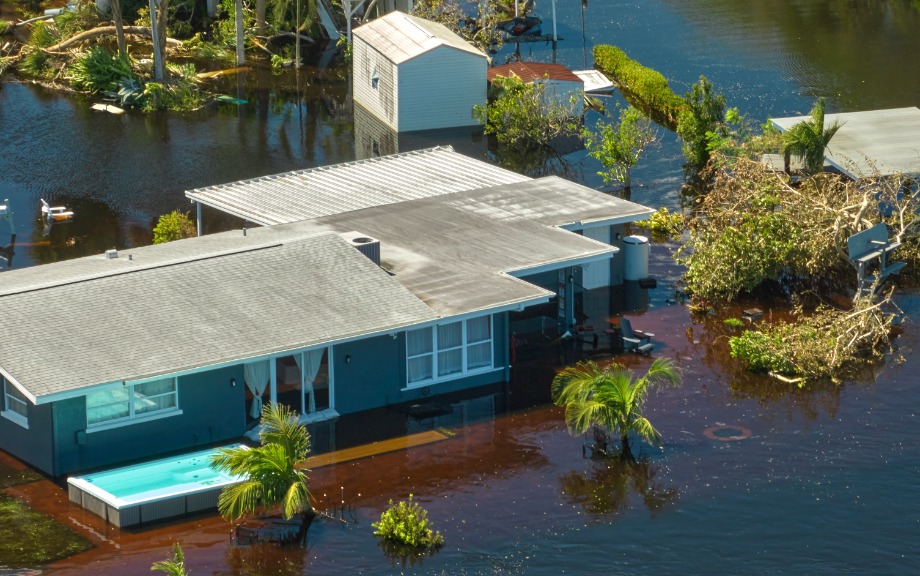 Photo: Blue house and property sitting in a flood; for a story on climate change.