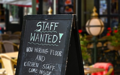 Decorative photo: Staff wanted recruitment sign outside a restaurant in Europe. No people.