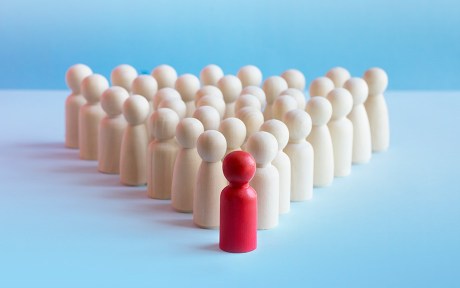 wooden figures in triangular formation with the lead figure colored red.