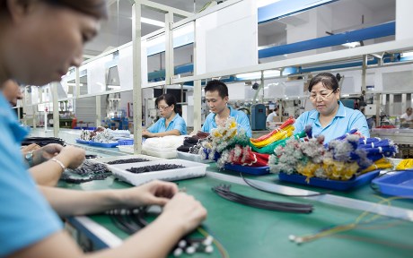 Decorative image: Chinese men and women assembling products in a factory?