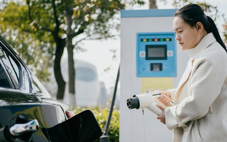  photo of woman charging an electric car