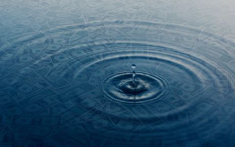 Decorative image of a drop of water hitting a pool of water with dollar bills under the water.