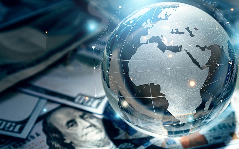 Photo: Crystal globe on many currency.