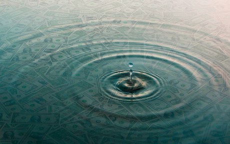 Decorative image: Ripple of water over dollar bills