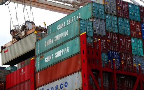 Photo of shipping containers in green and red with lettering stating China Shipping.