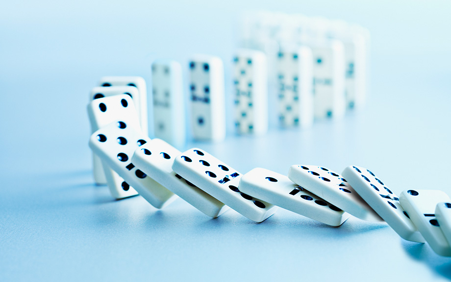 Photo: dominoes spilling on a blue background.