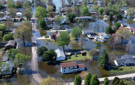 An aerial view shows floodwater surrounding homes on April 07, 2025 in East Prairie, Missouri. Thunderstorms, heavy rains, high winds and tornadoes have plagued the region for the past several days, causing widespread damage before moving east. (Photo by Scott Olson/Getty Images)