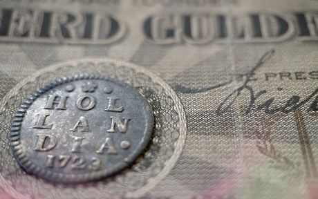 Photo: Old Dutch coins from the province of Holland with ancient Dutch banknotes.