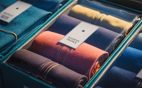 Photo: clothing items rolled in a box with label on it Made in France. AI generated