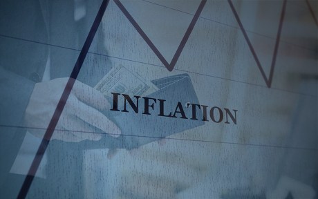 Photo: Man's hand holding a wallet, with Inflation text and line chart overlay