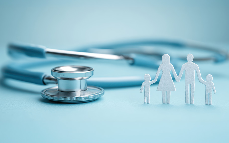 Photo: light blue background, with a stethoscope and white paper image of family standing up.